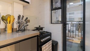 Una cucina con fornello, forno e diversi utensili.