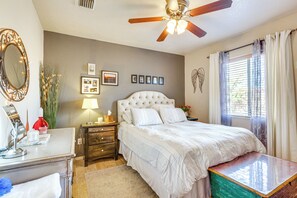 A bedroom with a bed, a nightstand, a dresser, a mirror, a ceiling fan, and a window with curtains. - Yuma Desert Oasis w/ Private Pool & Home Gym! (Yuma)