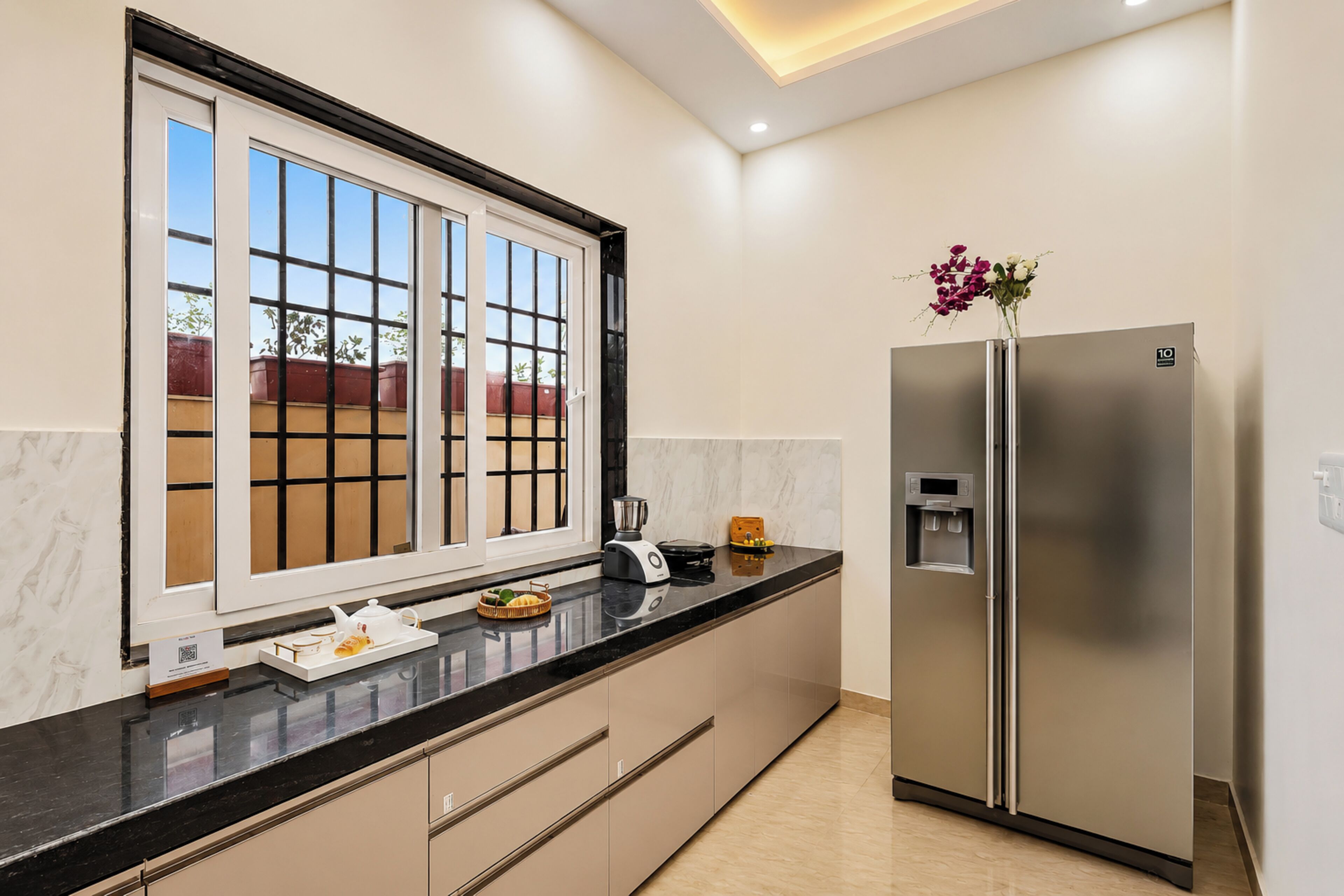 A modern kitchen with a large window, a refrigerator, and a water dispenser.