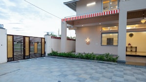 A modern house with a gated entrance, a covered porch, and a well-maintained garden. - Alaya Stays JSP Farm 4BHK Farmstay (Jaipur)