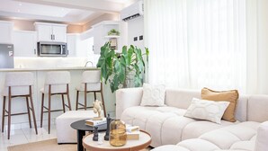 Ein modernes Wohnzimmer mit Sofa, Couchtisch und Barhocker.