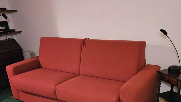 Een rode bank in een kamer met een groen tapijt.