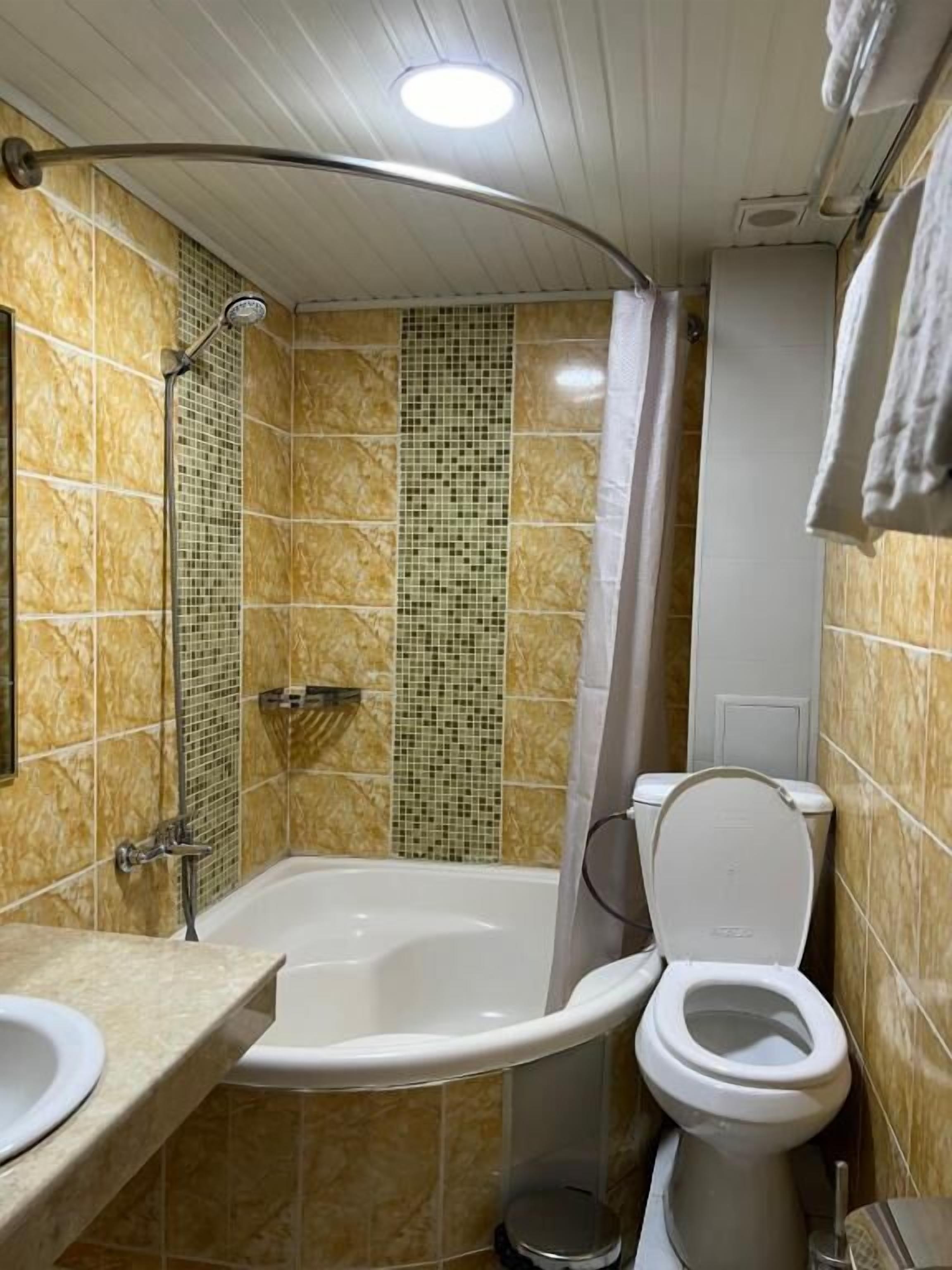 Een badkamer met bad, toilet en wastafel.