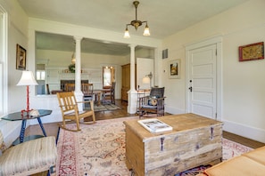 A spacious living room with a wooden coffee table, a rocking chair, and a dining area with a chandelier. - Yakima Wine Country! Orchards & Hop Yard On-Site (Wapato)