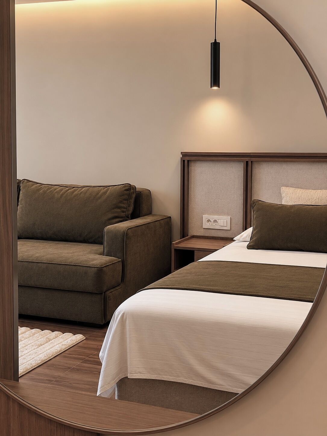 Una habitación de hotel con una cama, un sofá, una mesita de noche y un espejo.
