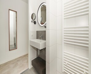 A bathroom with a white sink, two mirrors, and a towel rack. - Lake View Hotel Room 2p in Thorn (Thorn)