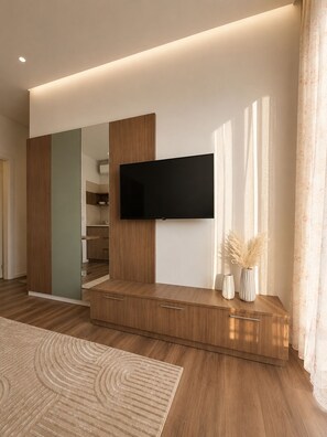 A modern living room with a flat-screen TV mounted on a wooden console, a staircase leading to an upper level, and a decorative vase with pampas grass. - Guest House Fjola : Family Two-Bedroom Apartment with View (Donji Štoj)