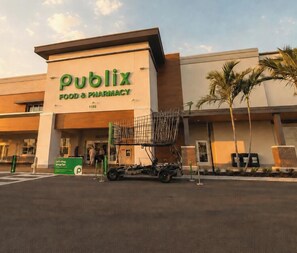 Un negozio Publix Food & Pharmacy con un grande cartello, un parcheggio e un carrello della spesa all'esterno.
