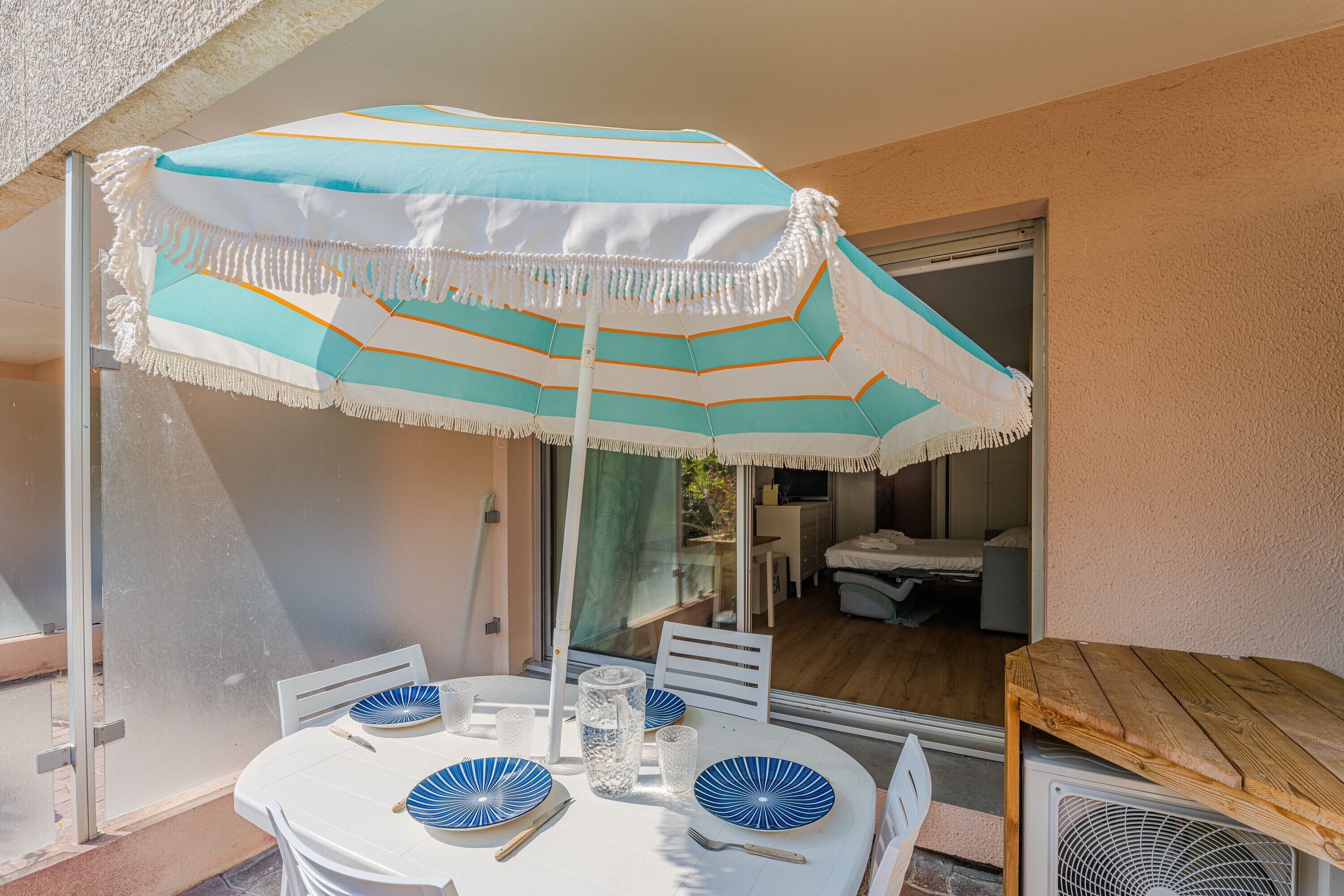 An outdoor dining area with a table, chairs, and a striped umbrella.