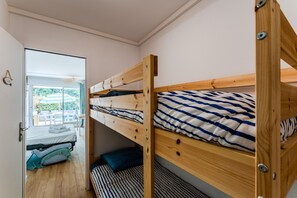 Et soveværelse med køjesenge, et vindue, en dør og udsigt til et udendørs område.