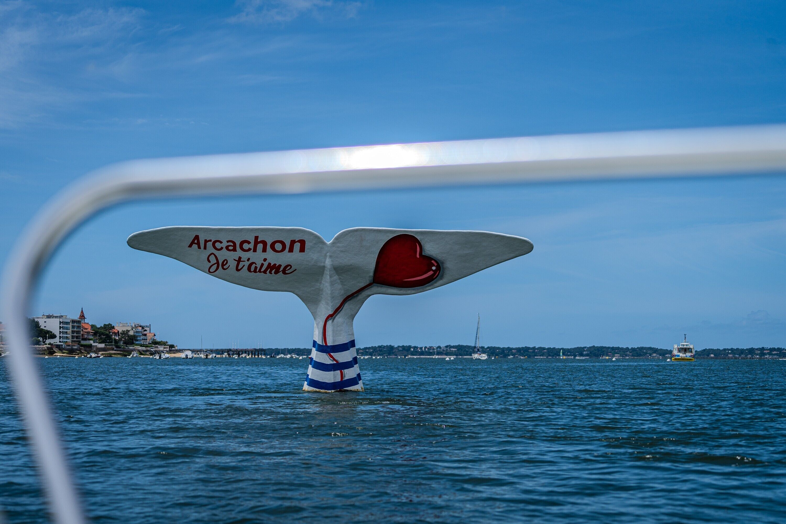 A boat with a whale tail fin featuring the text 'Arcachon Je t'aime' and a red heart.