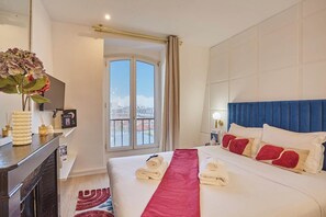 A hotel room with a bed, a desk, a window with a view, and a bathroom. - A charming haven in the heart of Montmartre (Paris)