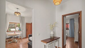 Ein Essbereich mit Tisch und Stühlen, einem Holzschrank und einem Spiegel, der einen anderen Raum widerspiegelt.