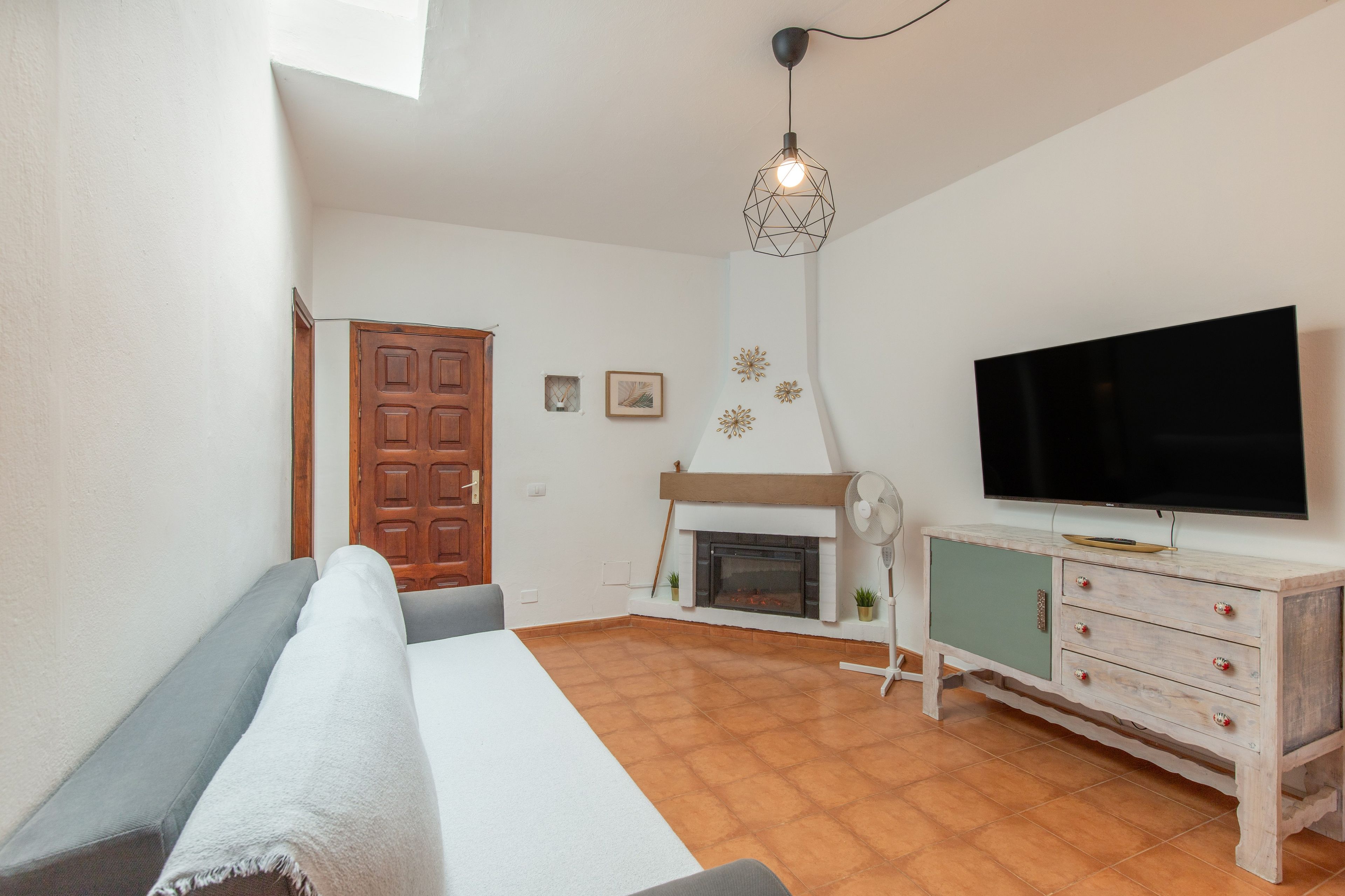 Un salon moderne comprenant un canapé, un téléviseur, une cheminée et un élément décoratif mural.