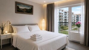 A hotel room with a bed, bedside table, lamp, window with curtains, and a painting on the wall. - Urban Rest Kalmar City (Kalmar)