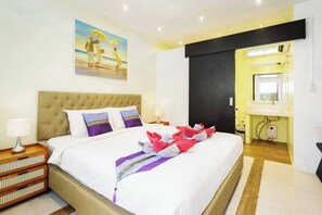 A hotel room with a bed, a painting, a nightstand, a lamp, and a bathroom with a mirror and sink.