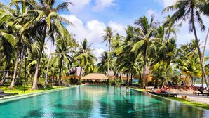 A clear swimming pool surrounded by palm trees, with lounge chairs and umbrellas. - Beach Villa 21D Blue Haven Bay Resort - 4 Rooms (Ko Chang)