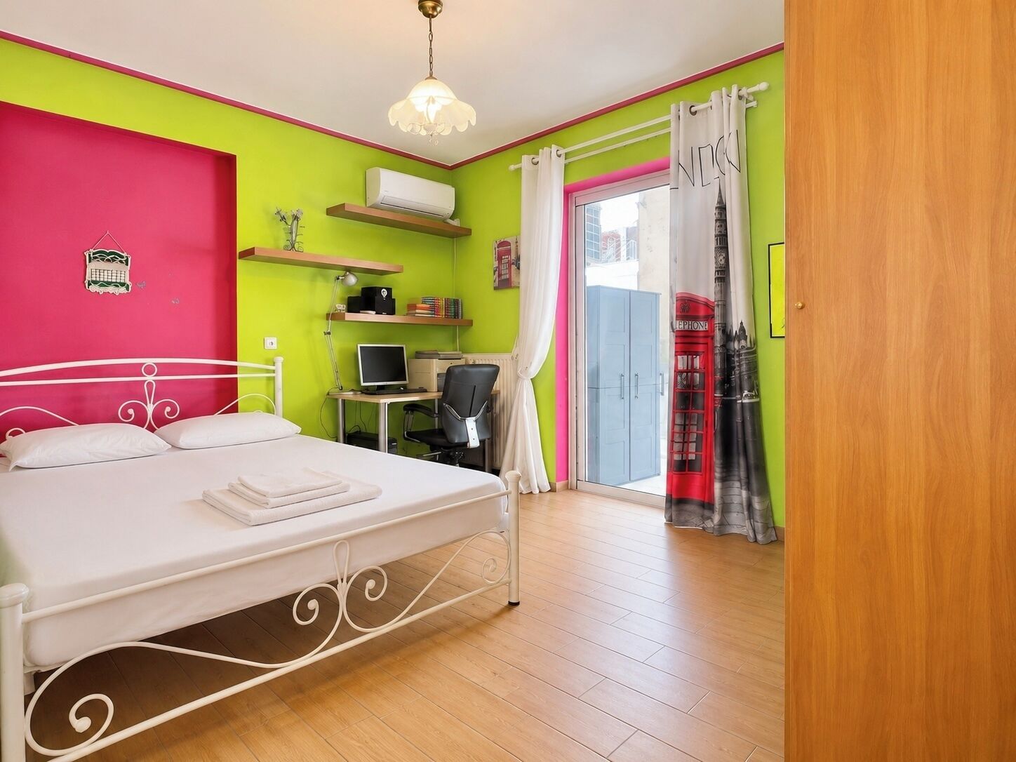 Ein Schlafzimmer mit Bett, Schreibtisch, Stuhl und Computer.