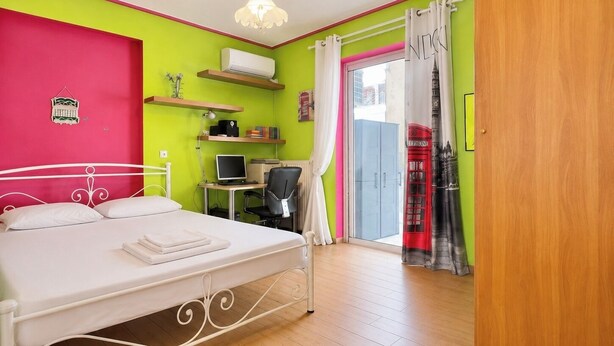 Une chambre à coucher avec un lit, un bureau, une chaise et un ordinateur.