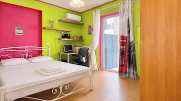 Ein Schlafzimmer mit Bett, Schreibtisch, Stuhl und Computer.