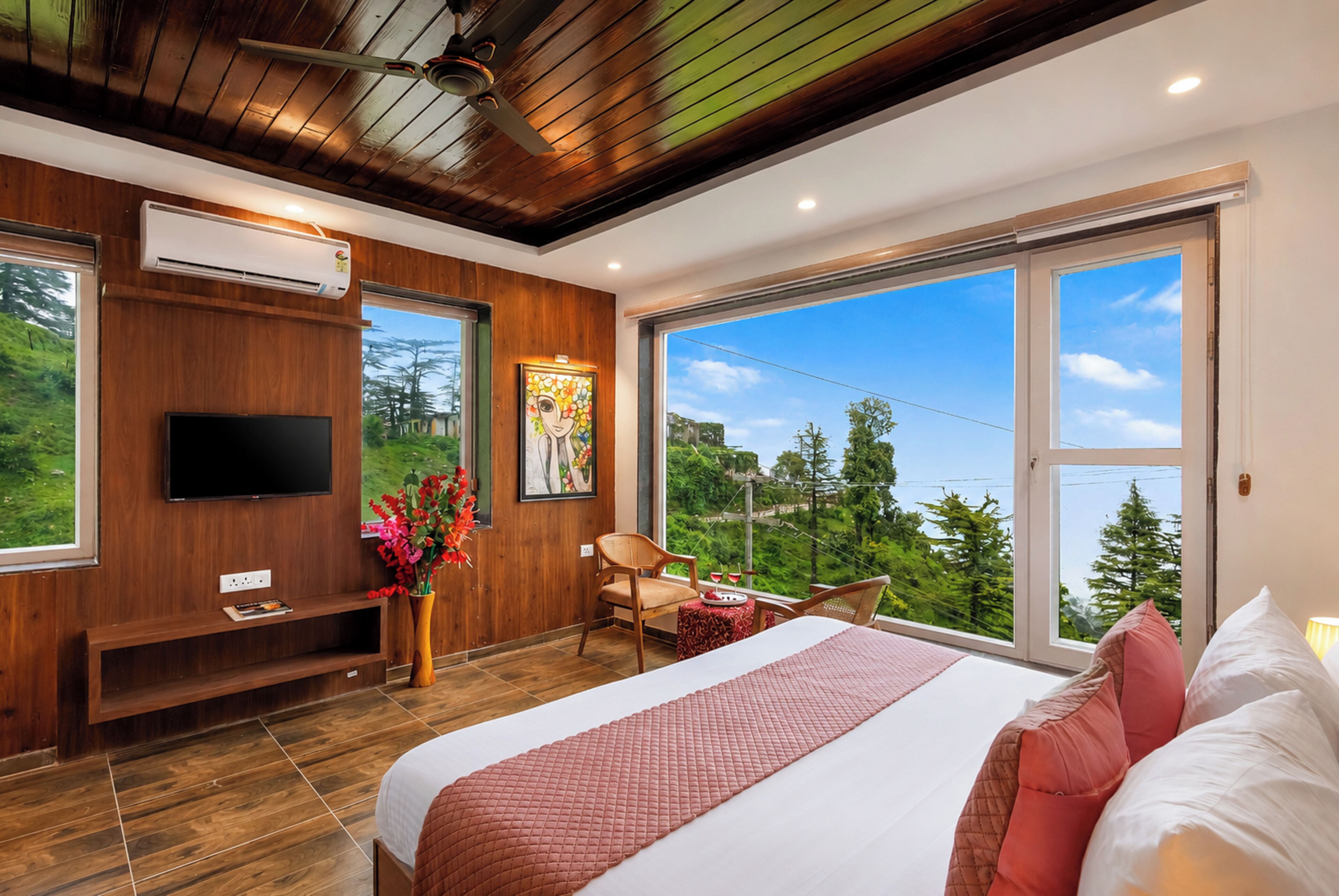 A modern bedroom with a large bed, a flat-screen TV, a painting, and a view of the outdoors.