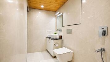 Ein modernes Badezimmer mit Holzboden, Toilette, Waschbecken und Dusche.