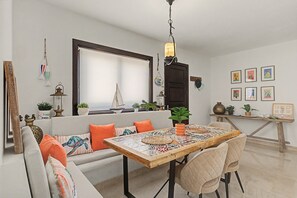 A dining area with a wooden table, cushioned seating, and a view of the outdoors. - Vacation Villa 'Eire' with Mountain View, Wi-Fi and Air Conditioning (Yaiza)
