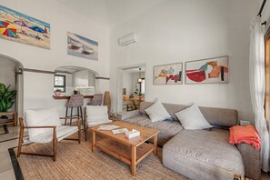 Ein Wohnzimmer mit einer Couch, Sesseln, einem Couchtisch und Kunstwerken an den Wänden.