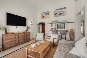 A modern living room with a flat-screen TV, wooden furniture, and artwork on the walls. - Vacation Villa 'Eire' with Mountain View, Wi-Fi and Air Conditioning (Yaiza)