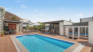 Une piscine avec des chaises longues et un espace équipé d’un jacuzzi.