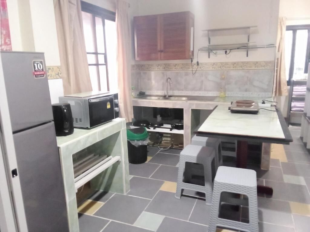 A compact kitchen with a refrigerator, microwave, and a sink.