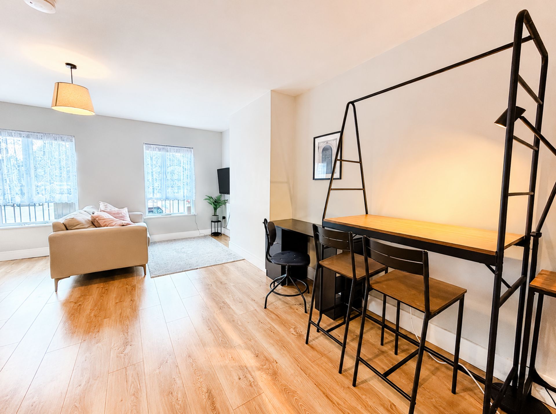 Ett modernt vardagsrum med en soffa, ett skrivbord med en stol och en stege.