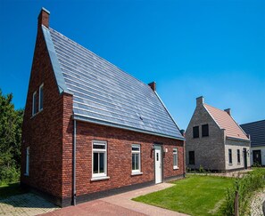 A residential building with a sloped roof, brick exterior, and a small front yard. - Luxe 12p Villa in Thorn (Thorn)