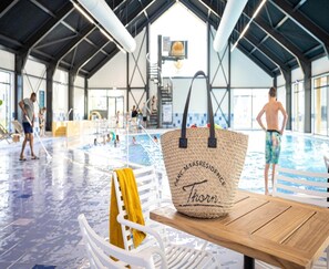A pool area with a wooden table and a woven bag on it. - Luxe 12p Villa in Thorn (Thorn)