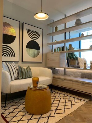 A modern living room with a sofa, a coffee table, and a bookshelf. - Tranquil Foreshore Studio Fully Equipped & Central (Cape Town)