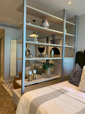 A modern bedroom with a bed, a built-in shelving unit, and a mirror. - Tranquil Foreshore Studio Fully Equipped & Central (Cape Town)