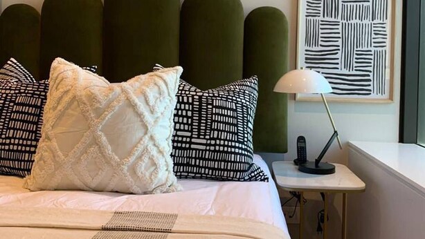 A hotel room with a bed, a bedside table with a lamp, and a framed abstract artwork on the wall. - Tranquil Foreshore Studio Fully Equipped & Central (Cape Town)