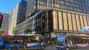A tall building with a modern glass facade, a storefront labeled 'FORESTORE PLACE,' and two buses parked in front. - Tranquil Foreshore Studio Fully Equipped & Central (Cape Town)