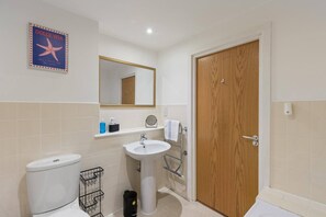 Ein Badezimmer mit Toilette, Waschbecken und Spiegel.