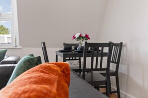 A dining area with a table, chairs, and a vase with flowers. - West Bridgford Luxury 2 bed 2 Bath Apartment (Nottingham)