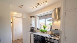 A compact kitchen with a gas stove, dishwasher, and a built-in oven. - Ultra-Spacious 2 BR In Central Wimbledon! (Greater London)
