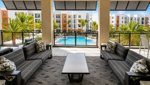 Ein Balkon mit Blick auf einen Pool, ausgestattet mit Sofas und einem Couchtisch.