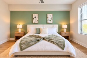 A bedroom with a bed, two nightstands, two wall-mounted lamps, and a window with blinds. - Luxury North Retreat with Pool and Gym (Naples)