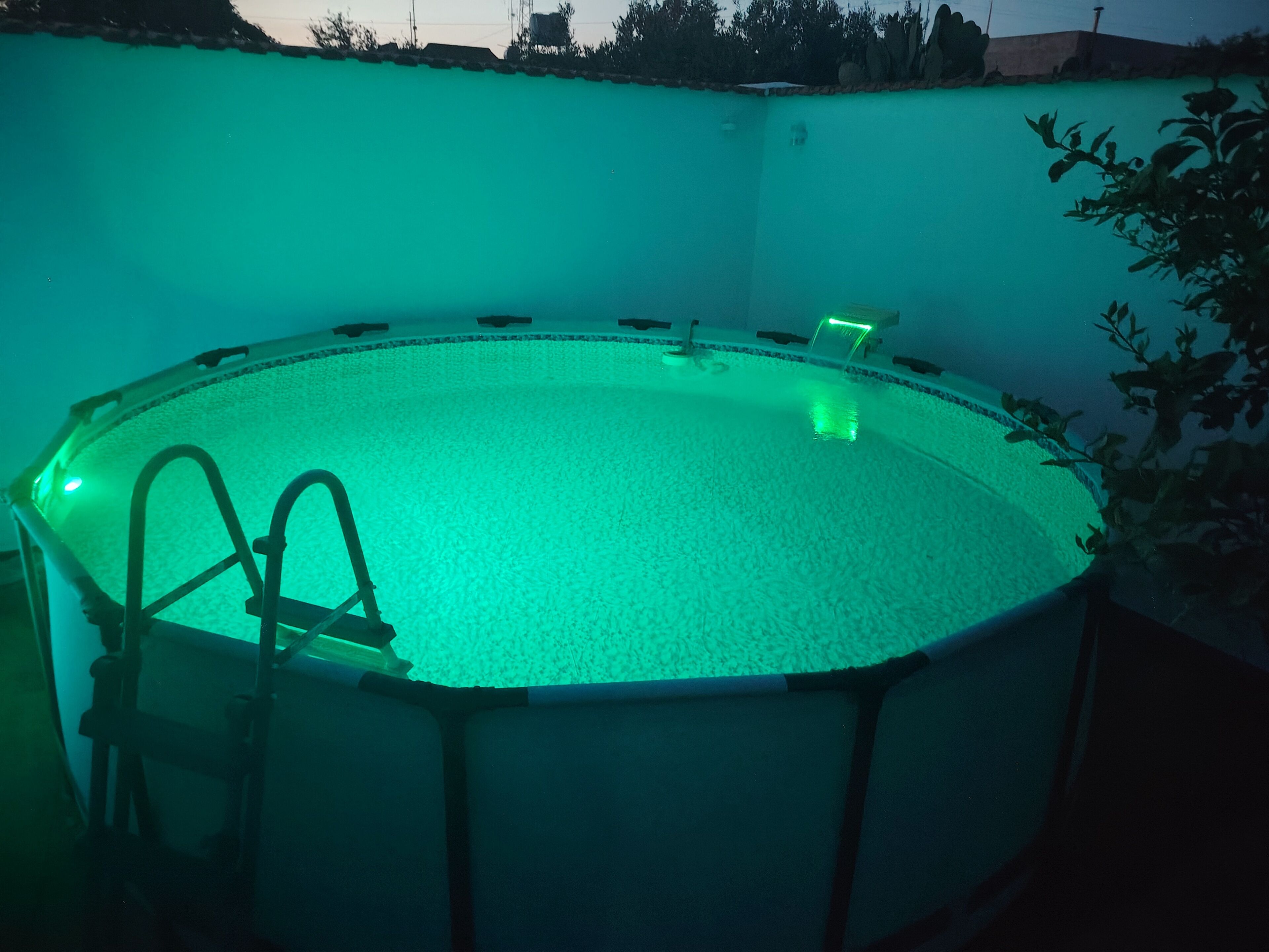 A circular swimming pool with a ladder and a single chair.
