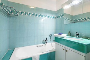 A bathroom with a bathtub, a sink, and a mirror. - Cozy Apartment Near Sea 4P - Cannes (Cannes)