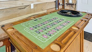 Ein Roulette-Tisch mit einem grünen Filzuntergrund und nummerierten Aussparungen, vor einem hölzernen Hintergrund.