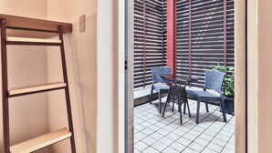 A room with a metal-framed window, a wooden ladder, and a small table with chairs. - Susu House (Seoul)