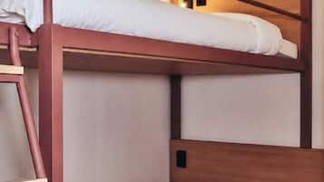 A bunk bed with a ladder, wooden headboard, and white bedding.