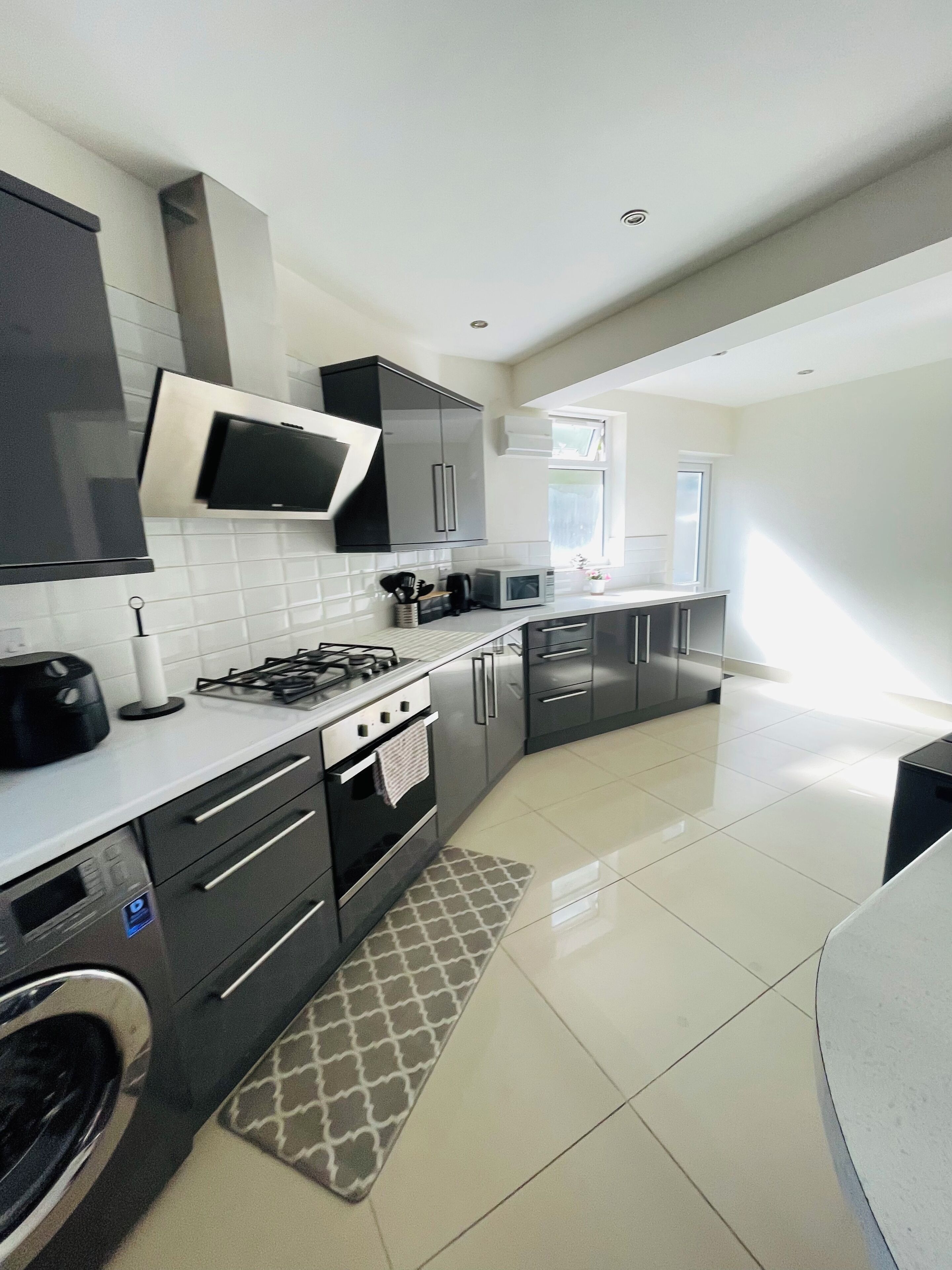 A modern kitchen with a gas stove, microwave, and stainless steel cabinets.