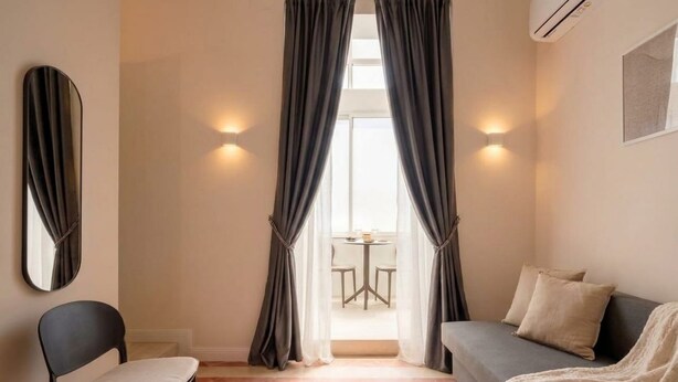 Une pièce comprenant un lit, une chaise, une table et des rideaux.